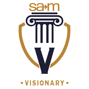 SAM Visionary badge featuring a gold and navy shield with a classical column at the center. The letter "V" is displayed prominently below the column, representing the Visionary giving level in the Pillars of Progress program. The SAM logo appears above the column.